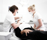 Zahnarzt Dr. Dahm mit Stuhlassistenz und Patienten