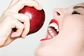 Frau kurz vor dem Biss in einen Apfel